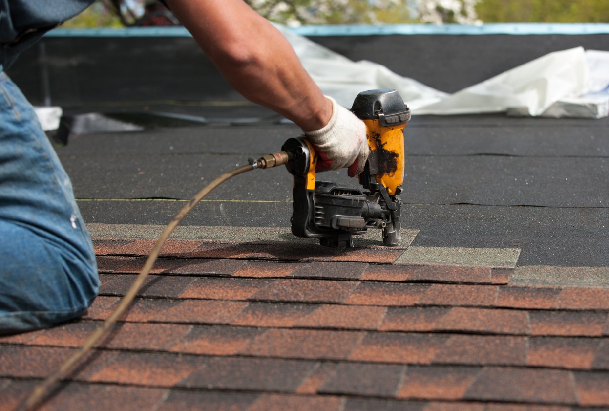 Roofing crew applying underlayment and flashing during residential install